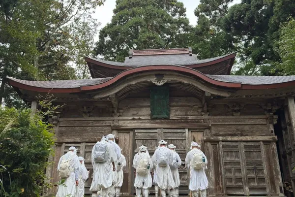 Yamabushi training group praying in front of a shrine in the mountains