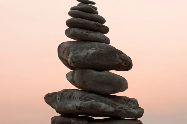 Closeup photography of cairn stones balanced on each other, representing the balance between knowledge and direct experience